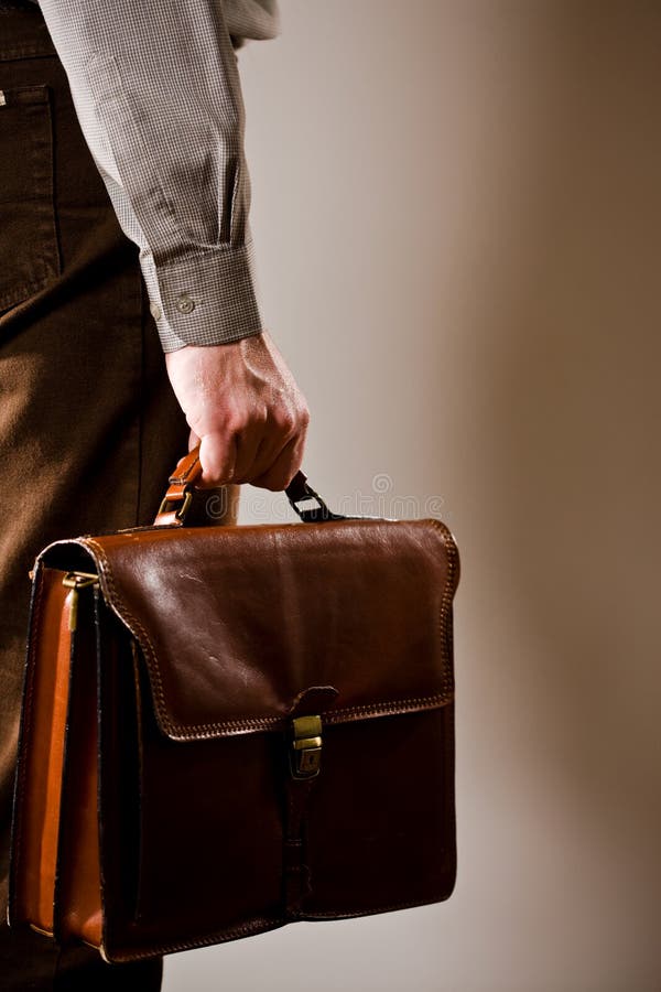 Business man holding elegant brown leather briefcase. Business man holding elegant brown leather briefcase.