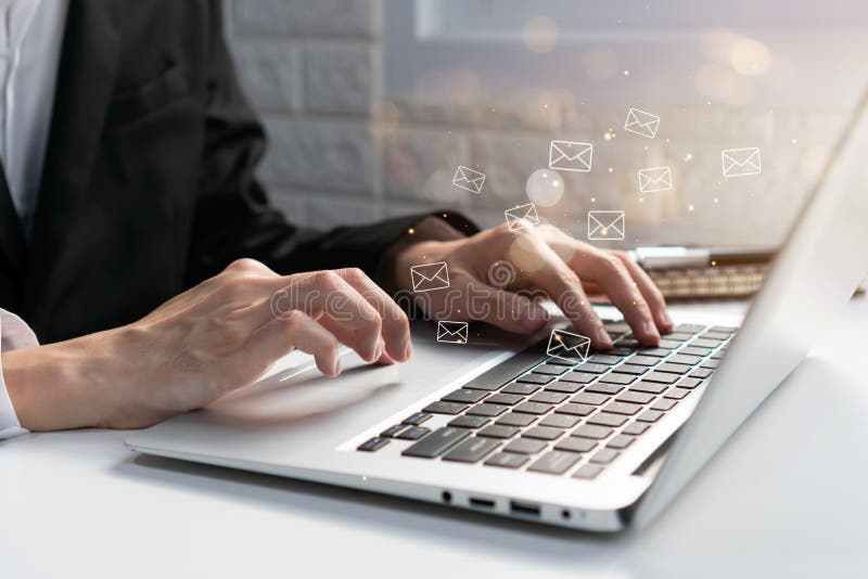 Businessman checking or sending online message on laptop with e-mail icons on background.