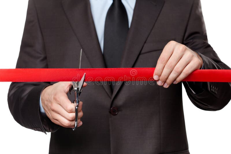 A businessman cutting a satin ribbon royalty free stock photography