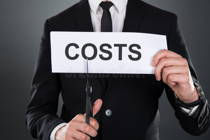 Businessman cutting the word costs on paper with scissors stock photography Businessman cutting the word costs on paper with scissors stock photography