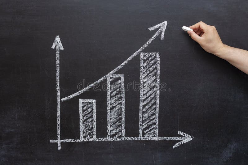 Businessman draws market growth chart on chalkboard stock photography