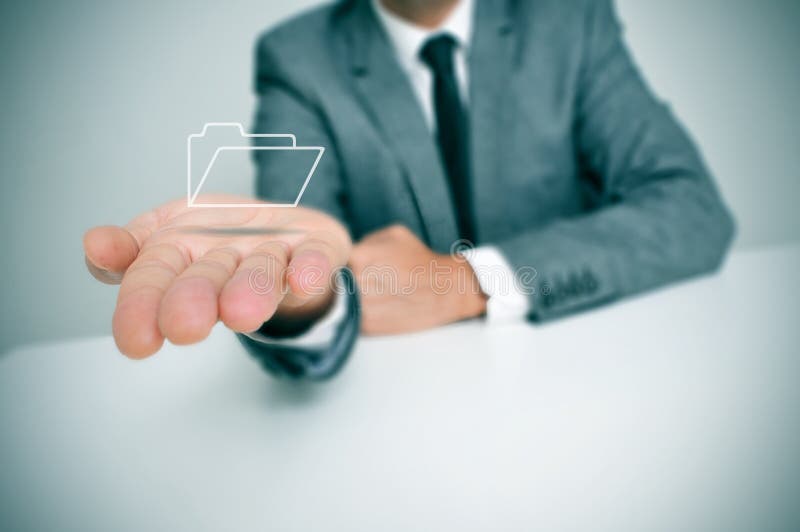 A businessman seating in a desk holding a folder icon in his hand. A businessman seating in a desk holding a folder icon in his hand