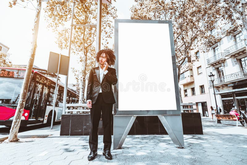 Businessman in a formal suit near empty urban banner mockup