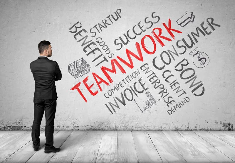 Businessman in full growth looking at white wall with sketches of teamwork formation. royalty free stock photos Businessman in full growth looking at white wall with sketches of teamwork formation. royalty free stock photos