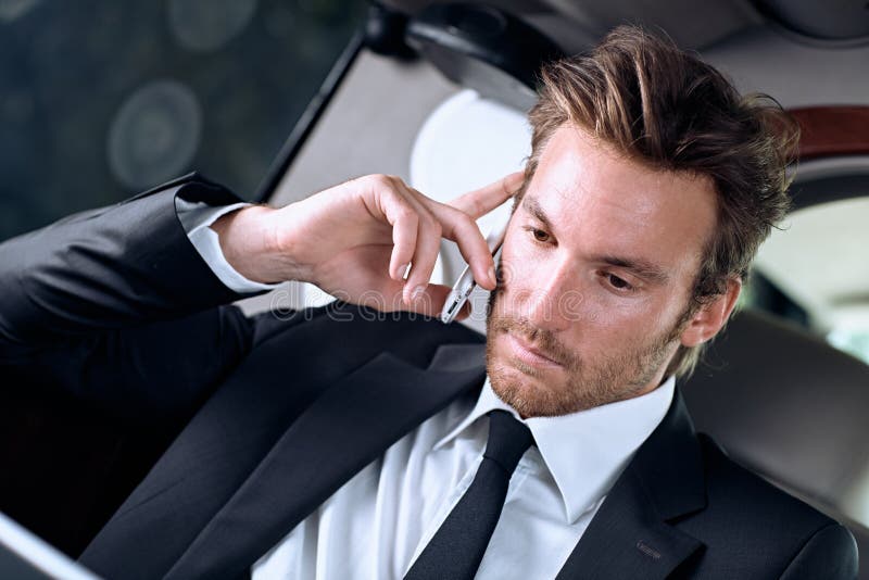 Businessman in full suit working while traveling in luxury car stock images Businessman in full suit working while traveling in luxury car stock images