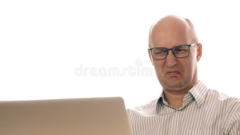 Businessman in glasses working at laptop saw disgusting image. Man made an expression of disgust while working in office