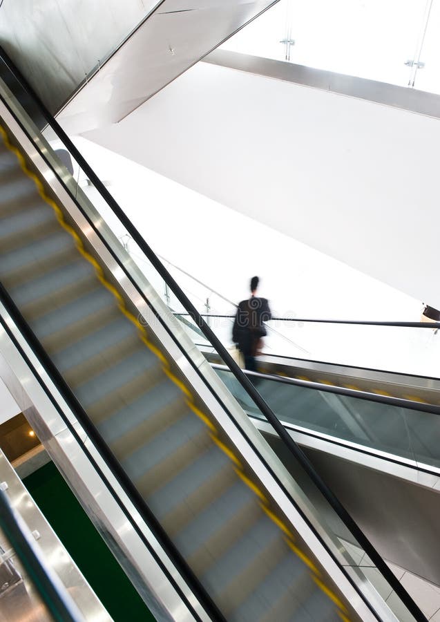 Businessman going down the escalator