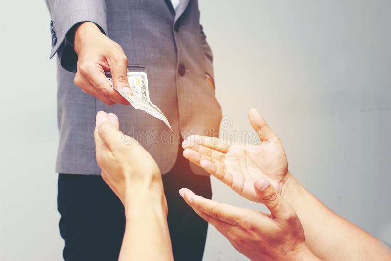 Businessman hand holding US dollar, USD. bills, offers dollar bank note money and giving money Paid for Something by Cash in Busin