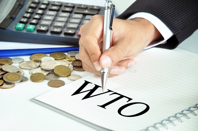 Businessman hand with pen pointing to WTO (or World Trade Organization) sign