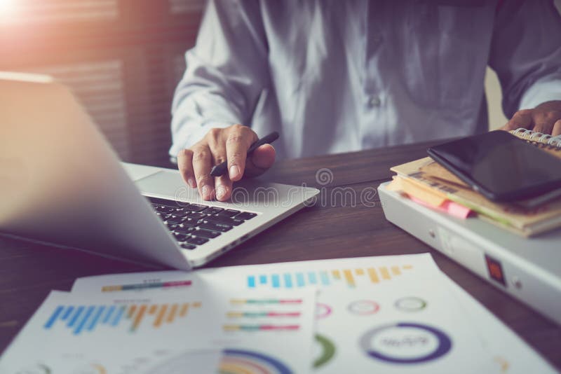 Businessman hand working laptop on wooden desk in office in morning light. The concept of modern work with advanced technology. royalty free stock photos