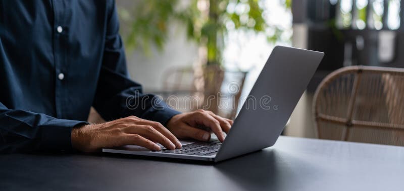 Businessman hands typing on laptop keyboard on table stock photo