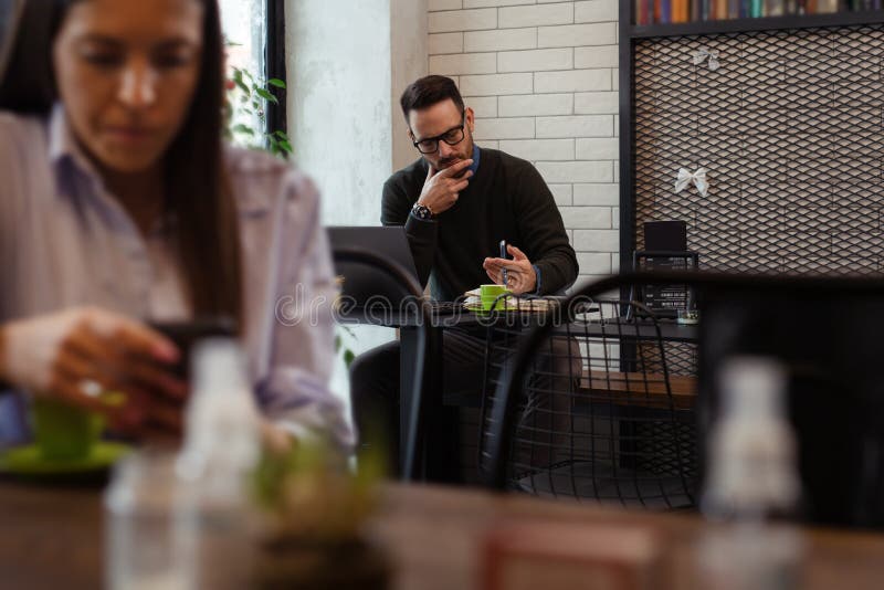 Businessman Having Coffee and Doing His Work in Cafe. Back Focus Stock