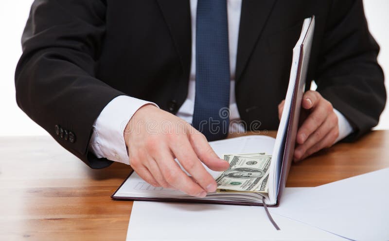 Businessman hiding money in the book royalty free stock photos Businessman hiding money in the book royalty free stock photos