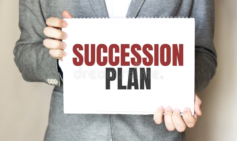 Businessman holding a card with text SUCCESSION PLAN royalty free stock photo