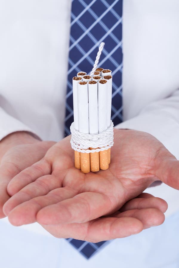 Businessman Holding Cigarettes Tied With Rope And Wick