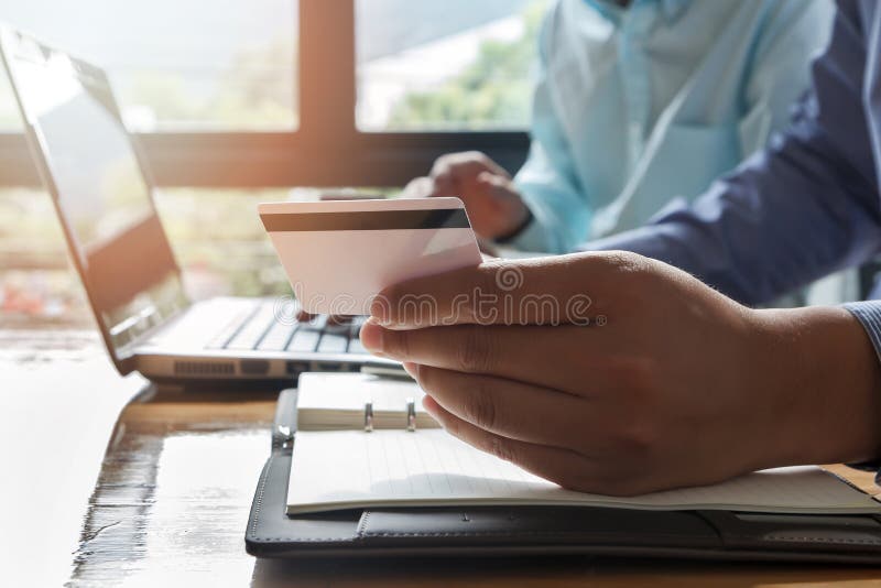 Businessman holding credit card and using laptop. stock images Businessman holding credit card and using laptop. stock images