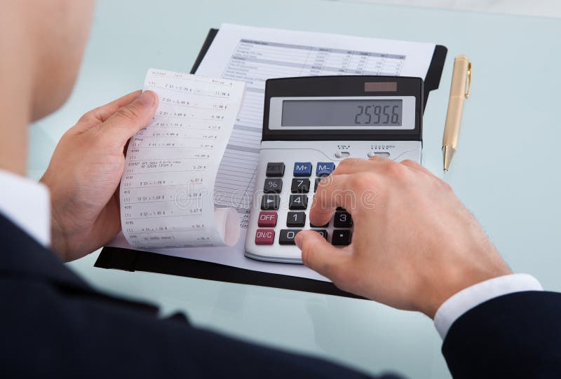Businessman Holding Receipt while Calculating Expense in Office Stock