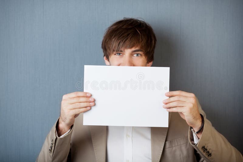 Businessman Holding White Paper Against Blue Wall