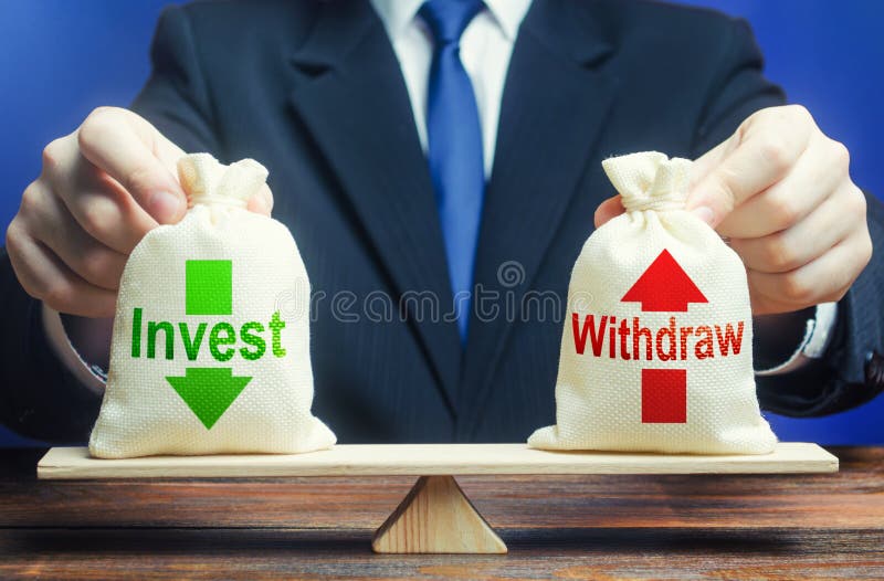 Businessman holds bags Invest and Withdraw on scales. Business profit management. Investment in a company national economy stock images