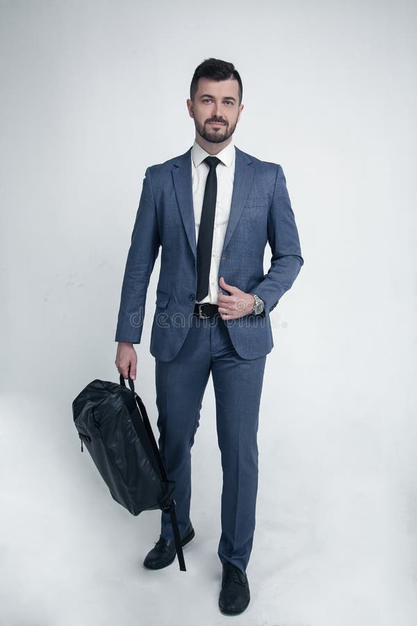 Businessman isolated on white background dressed in suit walking to the camera with bag in his hands stock photo Businessman isolated on white background dressed in suit walking to the camera with bag in his hands stock photo