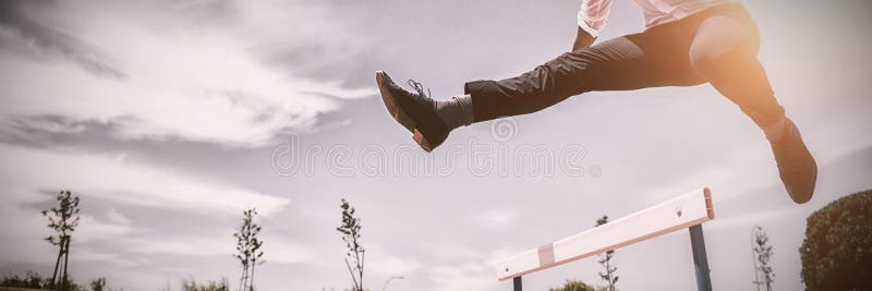 Businessman jumping a hurdle while running royalty free stock image Businessman jumping a hurdle while running royalty free stock image