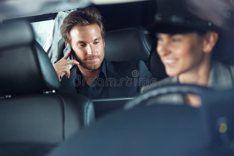 Podnikatel používat mobil v limuzína, žena šofér jízdy.