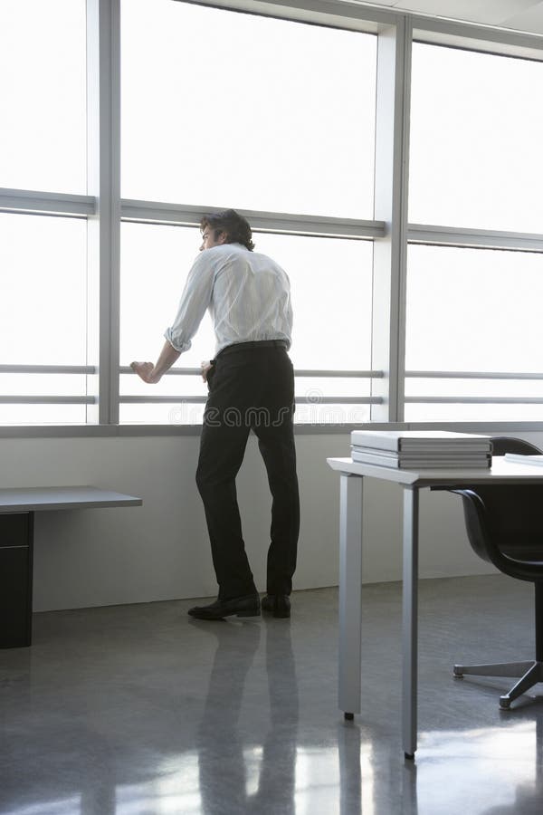 Businessman Looking Out Of Office Window