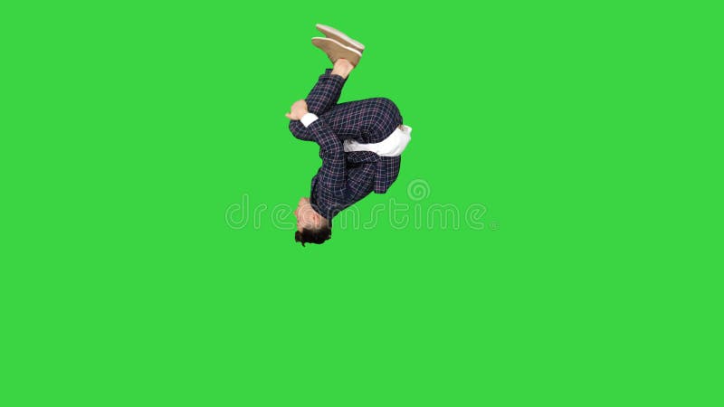 Businessman makes a back flip and shows cool gesture to camera after on a Green Screen, Chroma Key.