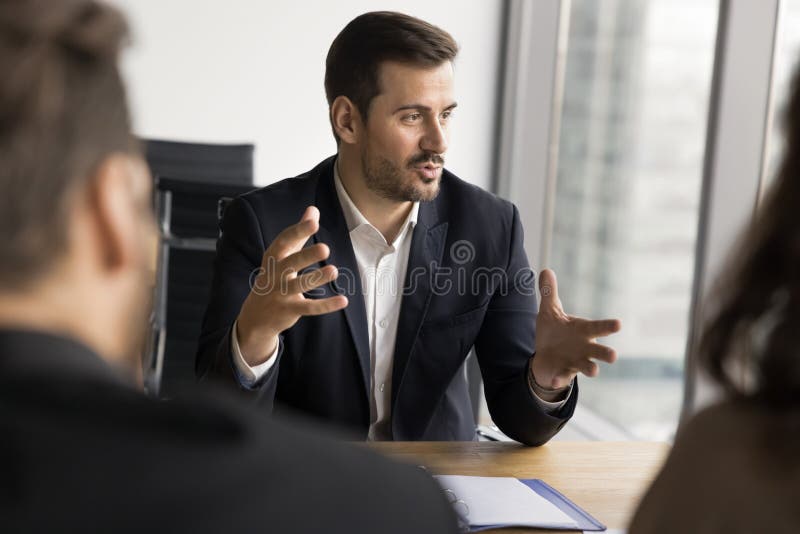 Businessman makes speech sits at table in front of shareholders stock image