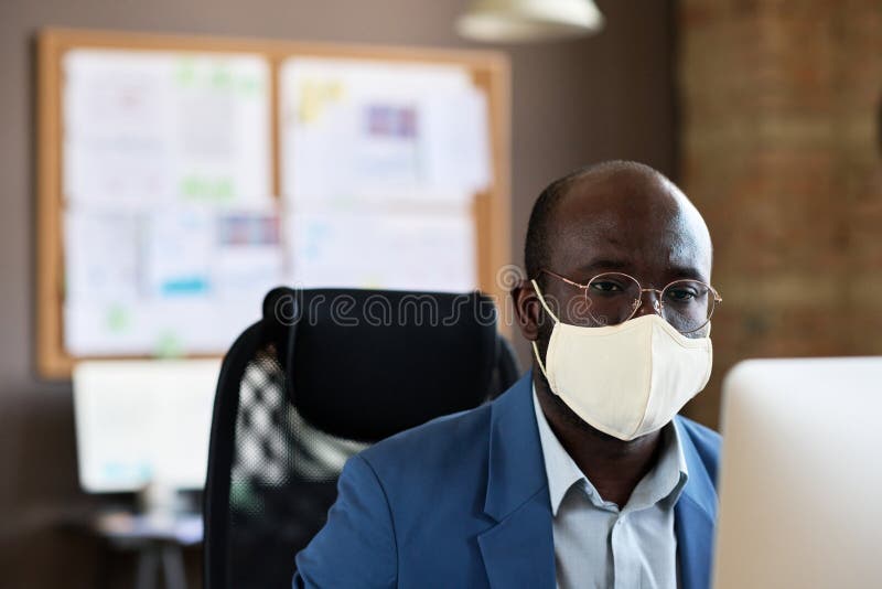Businessman in mask working at office royalty free stock photography