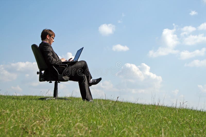 Businessman on office chair working with a laptop royalty free stock photos Businessman on office chair working with a laptop royalty free stock photos