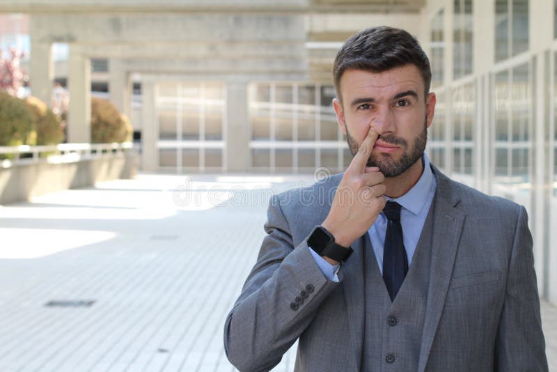 Businessman picking his nose in office space