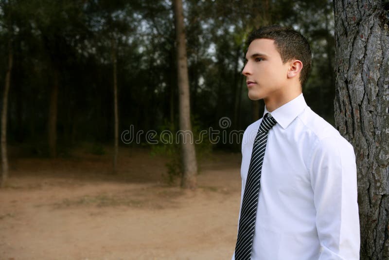 Businessman posing relaxed on a park forest