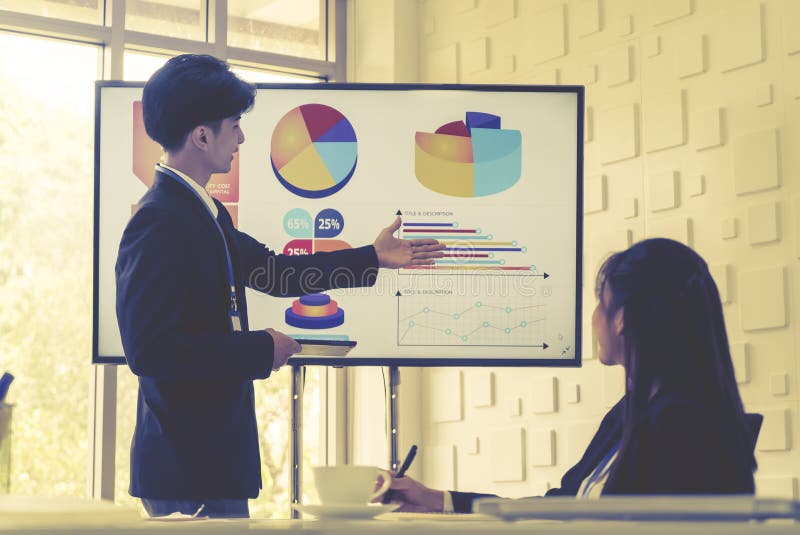 Businessman presenting work and flowchart on television monitor screen in a conference room royalty free stock image