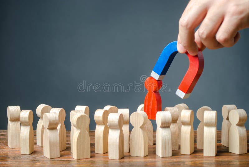 businessman pulls out a red figure of a man from the crowd with the help of a magnet. Increase team efficiency, productivity.