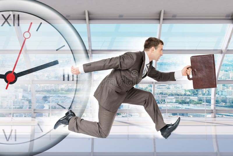 Businessman running with clock in building stock photography