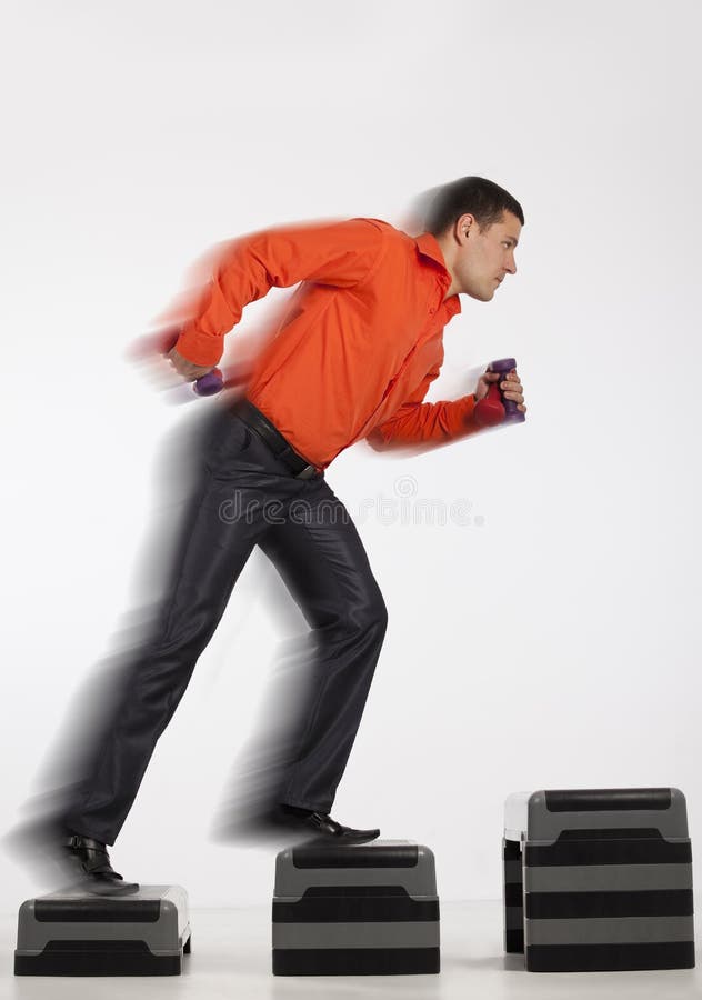 Businessman running up with dumbbells royalty free stock photo