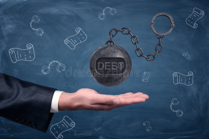 A businessman`s hand turned palm up under a large hovering iron ball with a word DEBT written on it.