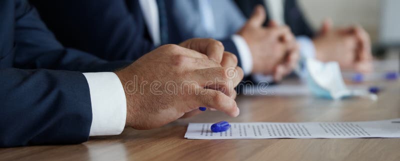 Businessman`s hands on the table next to the document. An official, boss, lawyer or businessman. Participation in the meeting and