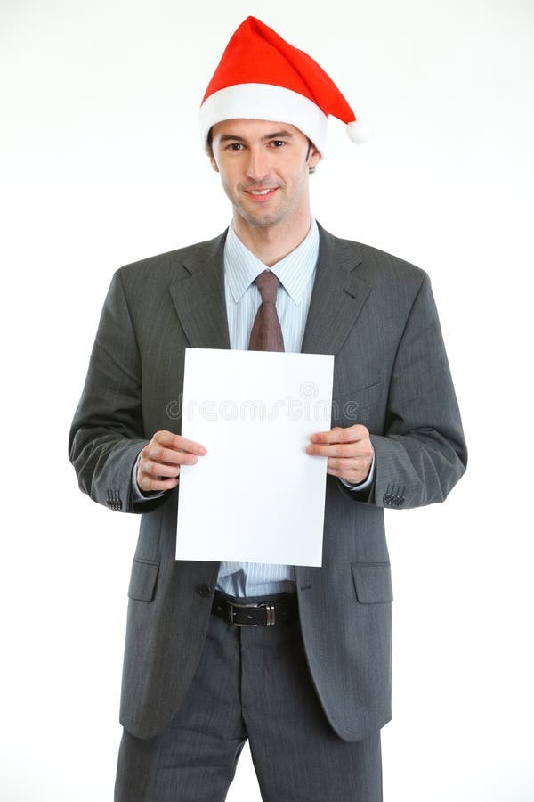 Businessman in Santas hat showing blank paper royalty free stock photo Businessman in Santas hat showing blank paper royalty free stock photo