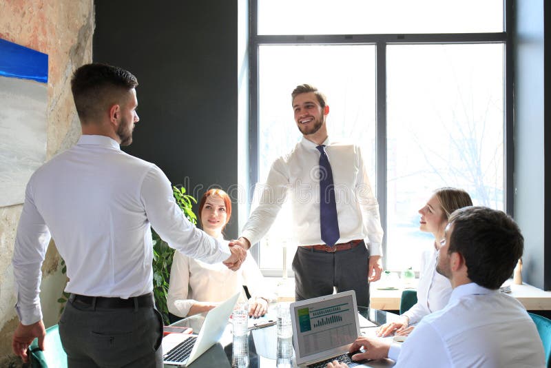 Businessman shaking hands to seal a deal with his partner and colleagues in office