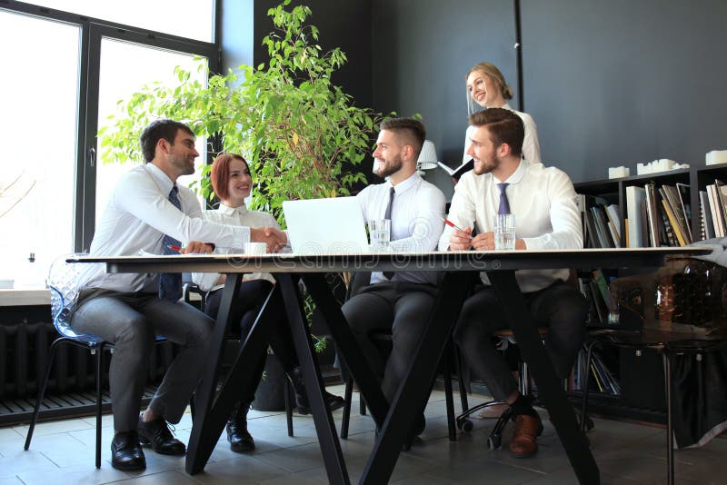 Businessman shaking hands to seal a deal with his partner and colleagues in office