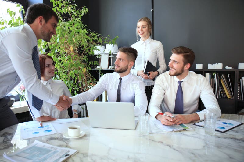 Businessman shaking hands to seal a deal with his partner and colleagues in office