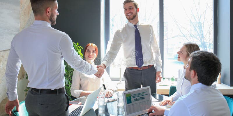 Businessman shaking hands to seal a deal with his partner and colleagues in office