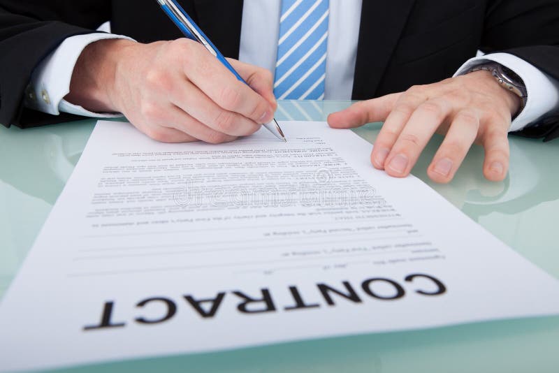 Businessman signing contract paper at office desk royalty free stock photography
