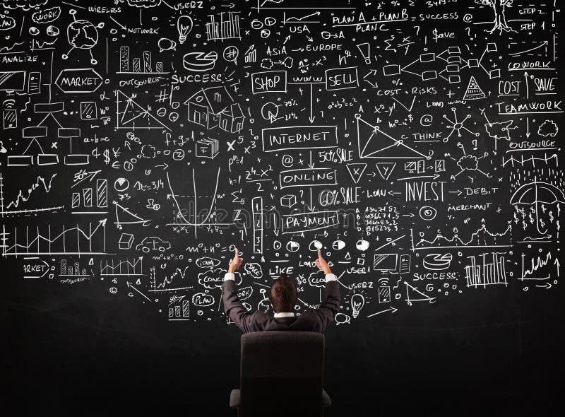 Businessman sitting in front of a blackboard with charts