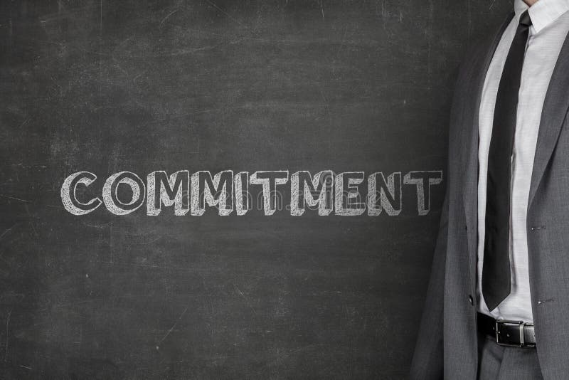 Businessman Standing By Commitment Text On Blackboard stock photos