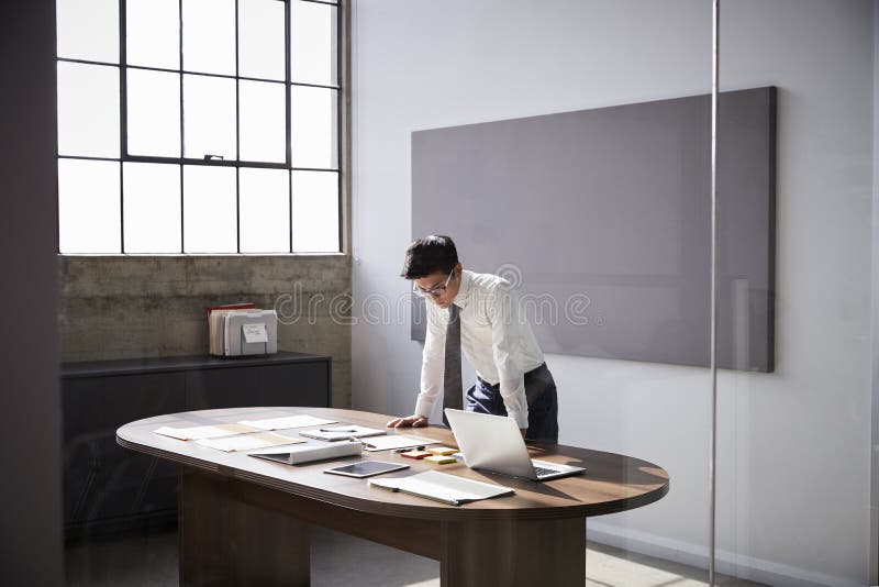 Businessman standing at desk working alone in an office