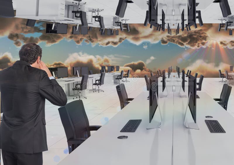 Businessman standing in inverted office in the clouds