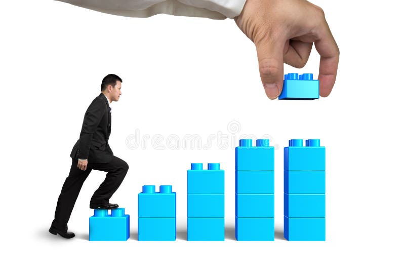 Businessman steps up bar graph stairs hand holding block complete